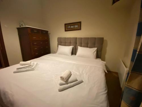 a bedroom with a white bed with towels on it at Petra house in Arachova