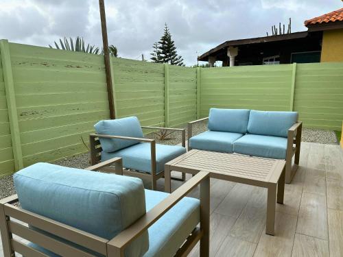 a patio with chairs and tables and a fence at Casa Papilon Family Home in Santa Cruz