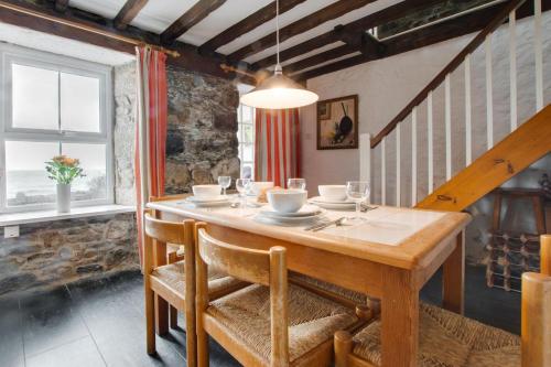 ein Esszimmer mit einem Holztisch und Stühlen in der Unterkunft St Michaels in Porthleven