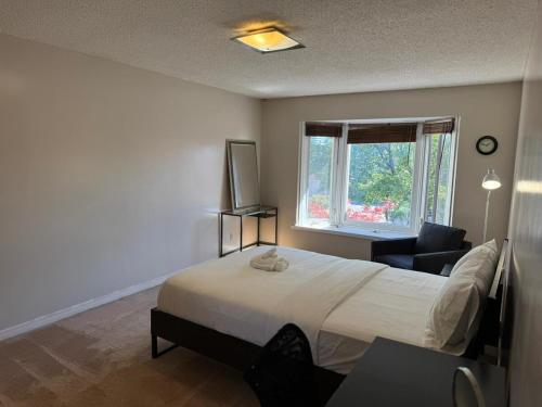 a bedroom with a bed and a chair and a window at Stylish Mississauga Escape Near Downtown in Mississauga