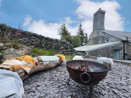 a fire pit in front of a stone house at 4 Bed in Betws y coed 52111 in Capel Garmon