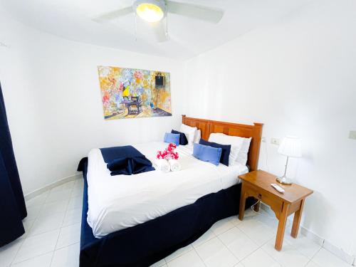 a bedroom with a large bed with blue and white pillows at DELUXE HOTEL SUITES STUDIO del Mar Bavaro TROPICANA HOTEL WIFI Beach CLUB & SPA in Punta Cana