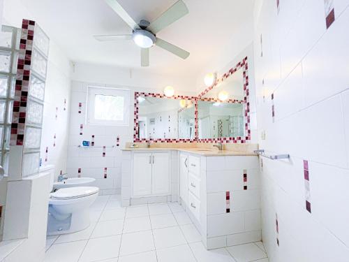 a bathroom with a toilet and a ceiling fan at DELUXE HOTEL SUITES STUDIO del Mar Bavaro TROPICANA HOTEL WIFI Beach CLUB & SPA in Punta Cana
