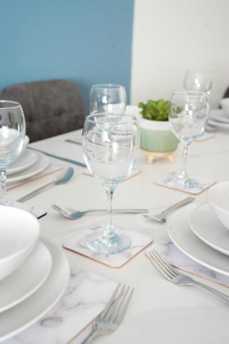 a table with white plates and wine glasses on it at Cliffburn House in Arbroath