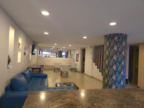 a living room with a blue couch and a table at Hotel Castellana 95 Bogota By Hoteles Confort 80 in Bogotá