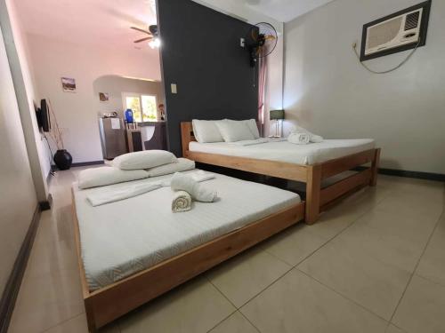 two beds sitting in a room with at Family 2 bed apartment with stunning sea views in Puerto Galera