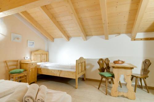 sypialnia z łóżkiem, stołem i krzesłami w obiekcie Roe Apartment w mieście Panchia