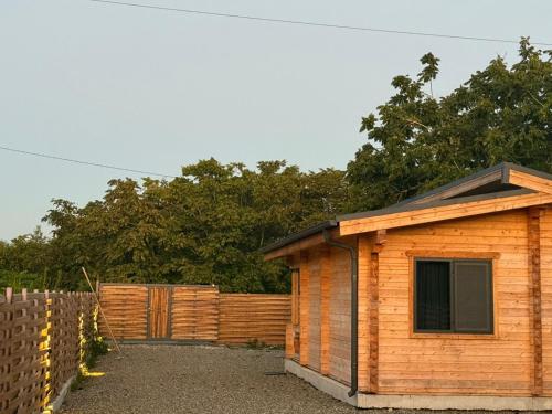 a small wooden shed sitting next to a fence at Meidan Oda Holiday Homes in K'obulet'i