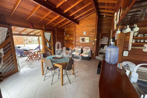 Casa Aconchegante – A 200m da praia da Pinheira في بينيرا: مطبخ وغرفة طعام مع طاولة وكراسي