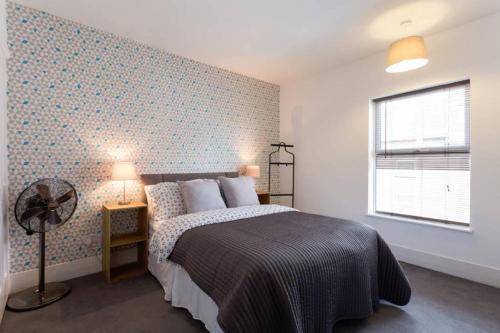 a bedroom with a bed and a wall at Ashton House in Luton