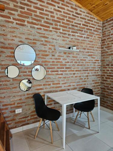 a white table and chairs against a brick wall at Acogedor loft estilo industrial in Posadas