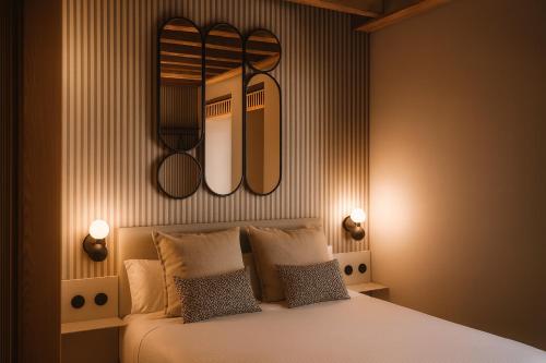 a bedroom with a bed with two lights above it at Hotel Spa Los Mercaderes in Talavera de la Reina