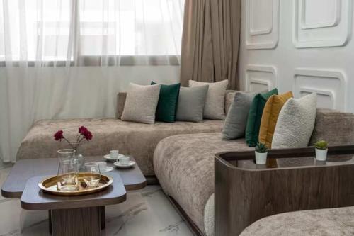 una sala de estar con un sofá y una mesa en Mansouria 1BR Pool View Beach Parking, en Minaret de Mansuria