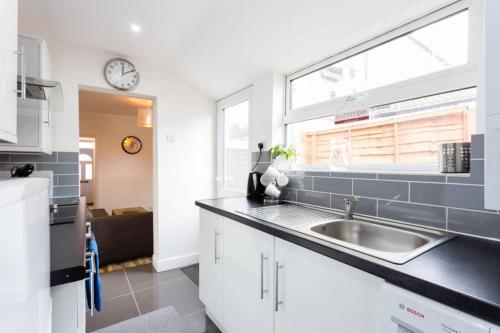 a kitchen with a sink and a window at Ashton House - Stylish 2 Bedroom House, Close to Luton Town Center & Airport in Luton