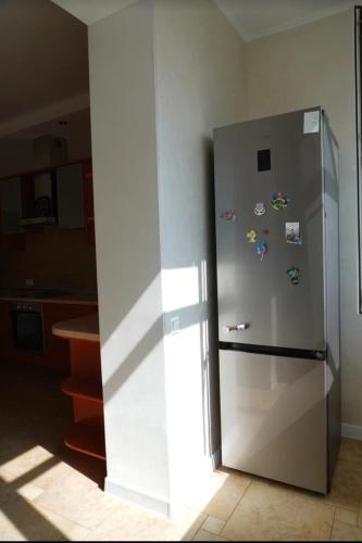 a stainless steel refrigerator in a kitchen at Dostyk Home in Zhezdi