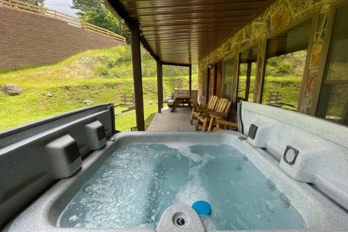 einen Whirlpool auf der Veranda eines Hauses in der Unterkunft Three Bears Lodge - Outdoor Hot Tub, Game Room, Pet Friendly + Chalet Village Resort Access in Chalet Village