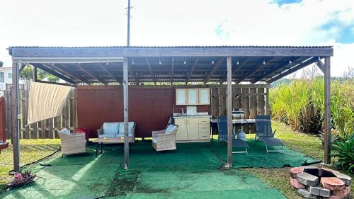 a pergola with chairs and a table in a yard at Canyon Breeze Dome in Barranquitas