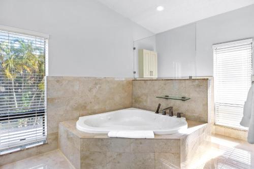 a large bathroom with a tub and a window at Cherry RoyaleGrand Villa in Davie