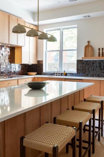 a kitchen with a large white counter with stools at 3.8 Million Dollar Brownstone Newly Renovated in New York