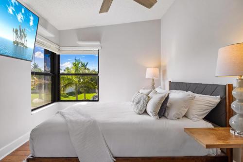 a white bedroom with a large bed and a window at Cherry RoyaleGrand Villa in Davie