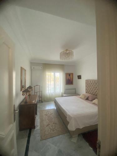 a bedroom with a bed and a table and a window at Joujou Aprt in Monastir