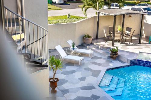 a patio with a pool and a table and chairs at Cherry RoyaleGrand Villa in Davie