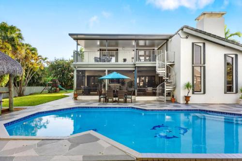a house with a swimming pool in front of a house at Cherry RoyaleGrand Villa in Davie