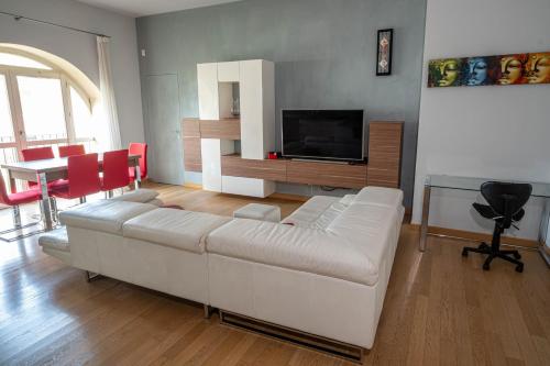a living room with a white couch and a television at Il Castello - Appartamento in zona residenziale in Modena