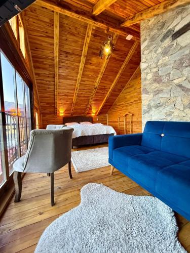 a living room with a blue couch and two beds at İsgobya Dağ Evleri 107 in Macka