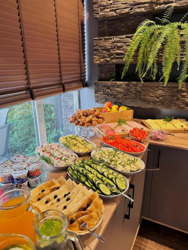 a buffet with many plates of food on a table at Płonia Resort in Szczecin