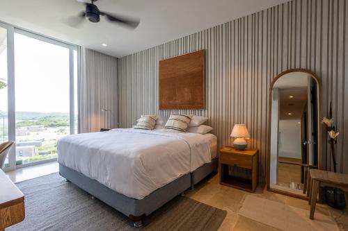 Un dormitorio con una cama grande y una ventana grande en 4BR Seaview Apartment at Calablanca D5, en Pendales