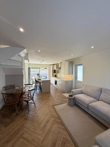 a living room with a couch and a table at Coastal Calm at Stanpit Hideaway in Christchurch