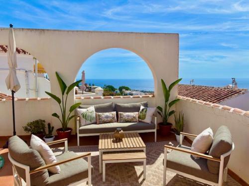 patio z kanapą i krzesłami oraz oceanem w obiekcie Casa Paz - 2 bedroom - Terrace VIEWS & hot tub w mieście Nerja