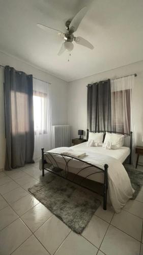 a bedroom with a bed and a ceiling fan at My Sweet Home in Tríkala