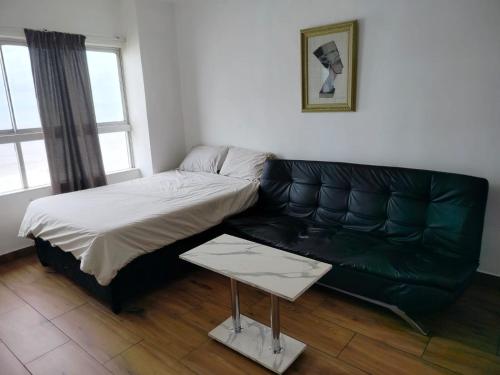 a bed and a couch in a room at Beach Front Self Catering Apartment With Pool in Durban