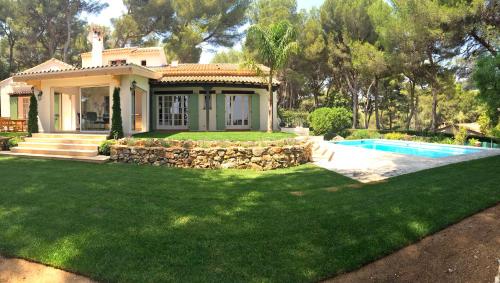 a house with a pool in front of a yard at Villa Defendum in Vallauris