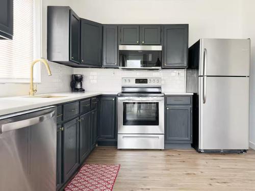 a kitchen with black cabinets and a white refrigerator at Evansville Holiday House in Evansville