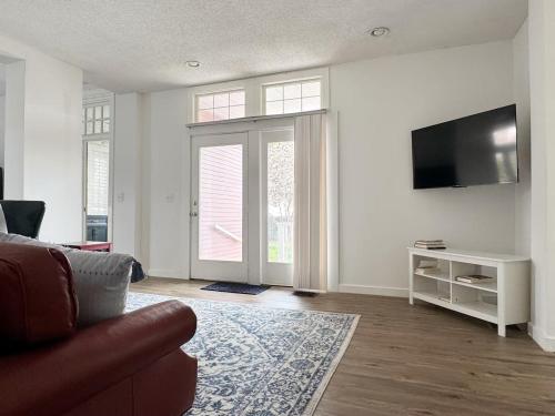 a living room with a couch and a flat screen tv at Evansville Holiday House in Evansville