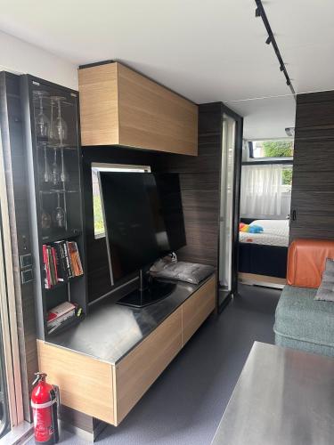 a room with a kitchen with a tv and a bed at Beautiful, luxurious Caravane property in Rothrist