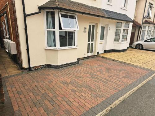 a brick driveway in front of a house at StayZen Apartments - Private Garden & Free Parking Ground Floor Central Woking - Business & Leisure in Woking