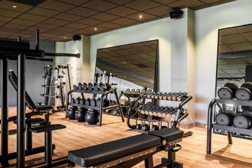 a gym with a lot of treadmills and weights at NH Noordwijk Conference Centre Leeuwenhorst in Noordwijkerhout