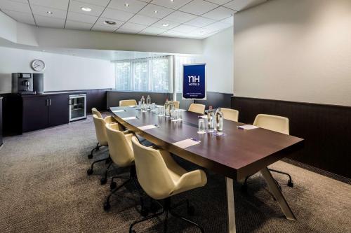 a conference room with a long table and chairs at NH Noordwijk Conference Centre Leeuwenhorst in Noordwijkerhout