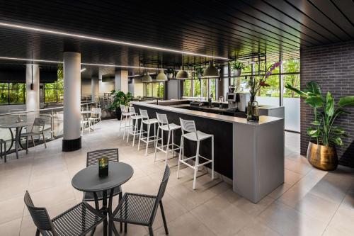 a restaurant with a bar and tables and chairs at NH Noordwijk Conference Centre Leeuwenhorst in Noordwijkerhout