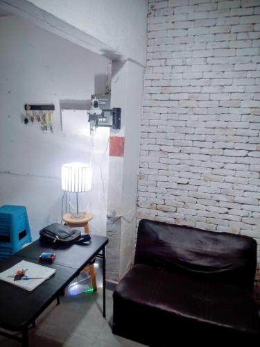a living room with a black leather couch and a table at Posada María Elvia in Villahermosa