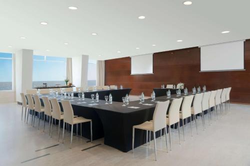 a conference room with a long table and chairs at NH Montevideo Columbia in Montevideo