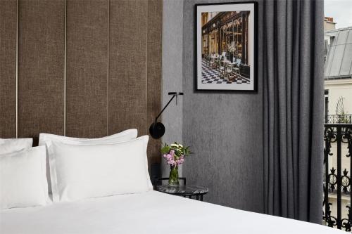 a bedroom with a bed and a picture on the wall at NH Paris Opéra Faubourg in Paris