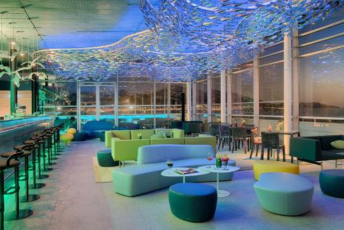 a restaurant with blue ceilings and tables and chairs at nhow Marseille in Marseille