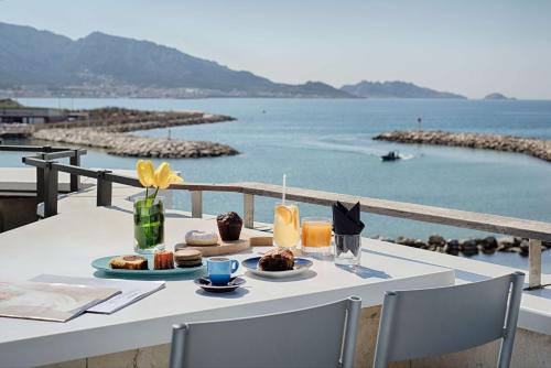 a table with food on it with a view of the water at nhow Marseille in Marseille