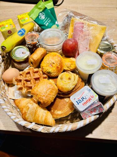 a basket of food with bread and other foods on a table at Containers aménagé au cœur des chants des grenouilles in Hotton