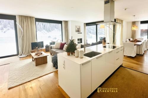 a kitchen and living room with white cabinets at Schooren des Alpes Luxury Penthouses & Apartments with SPA & Pools close Ischgl in Kappl